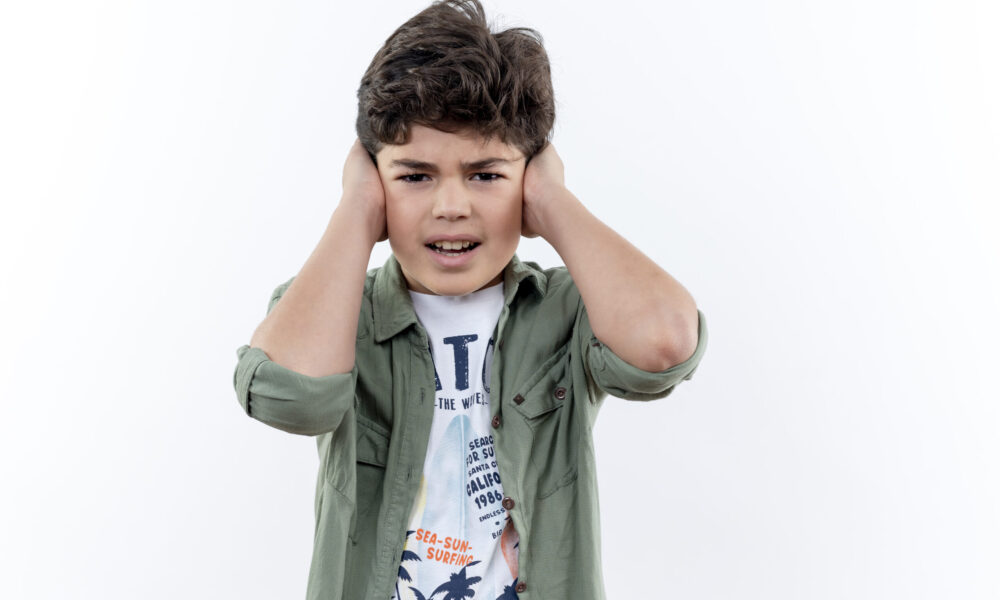 Child experiencing symptoms of otitis media with ear pain and discomfort.